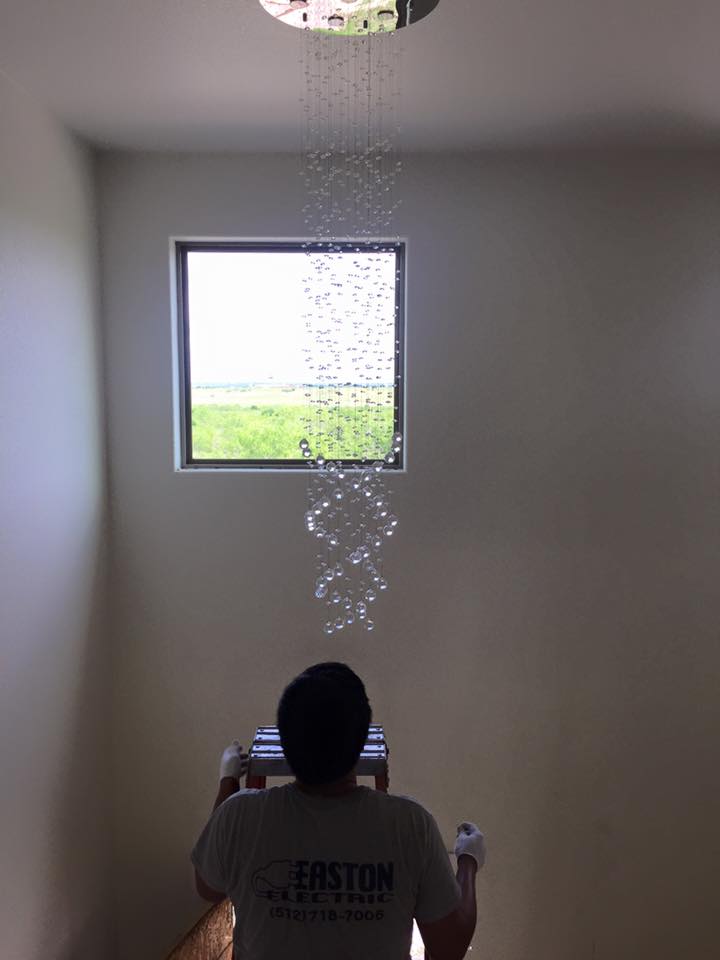 Chandelier installation in a stairwell